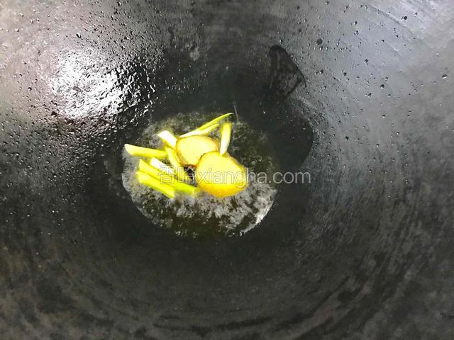 热锅给油烧至五成热，放入葱段和姜片爆香