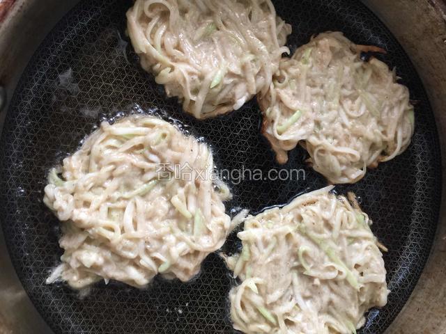 平底锅加底油烧热，用勺子挖着葫芦丝成球状开始煎，稍一成型压成饼