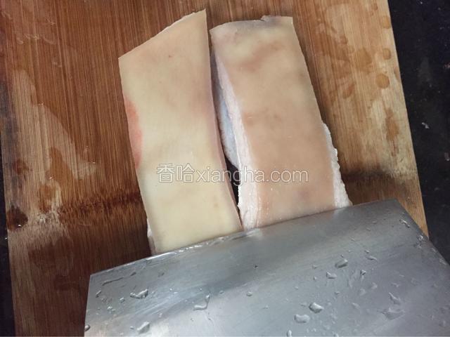 开水中焯过的五花肉用刀在皮上刮数下去毛，刮不下的可以用手或工具揭一下。