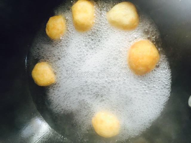 水开后放入炸好的鱼丸，煮一会儿。