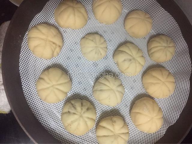包馅的面团一个个摆在放了蒸笼布的蒸笼里，每个面团之间空出间隙，以便用与面球的发酵变大。
