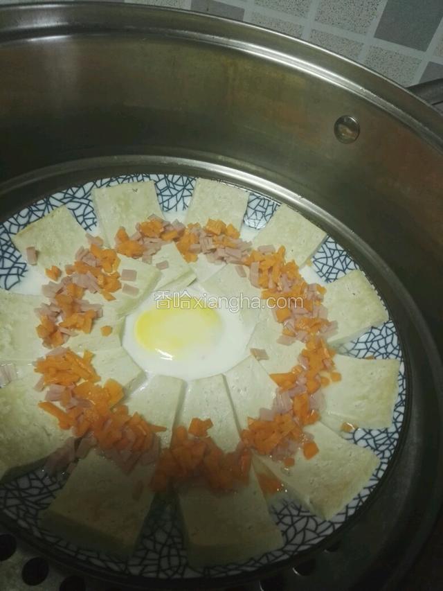 大火蒸八分钟，放火腿粒和胡萝卜粒，继续蒸五分钟出锅