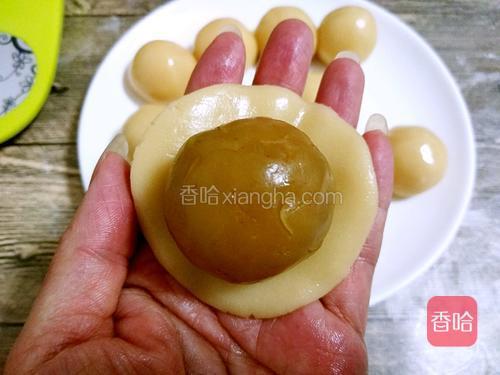 取一个月饼皮按扁成饼状，放入莲蓉蛋黄馅