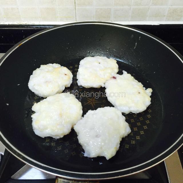 煎至一面凝固，翻面煎另一面。
中小火煎。
中途可以多次翻面，受热才均匀，墨鱼饼才会熟透。
