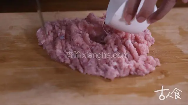 在中间做一个窝儿，加入半杯凉水，加水之后要快速剁，剁好后把肉摊平