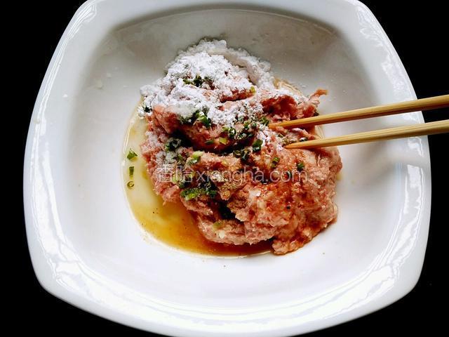 剁好的肉糜加入料酒、蛋清、淀粉、胡椒粉、盐、生抽、味极鲜、葱花，用筷子搅拌。