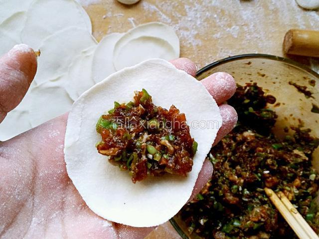 取一张饺子皮，中间放入适量肉馅