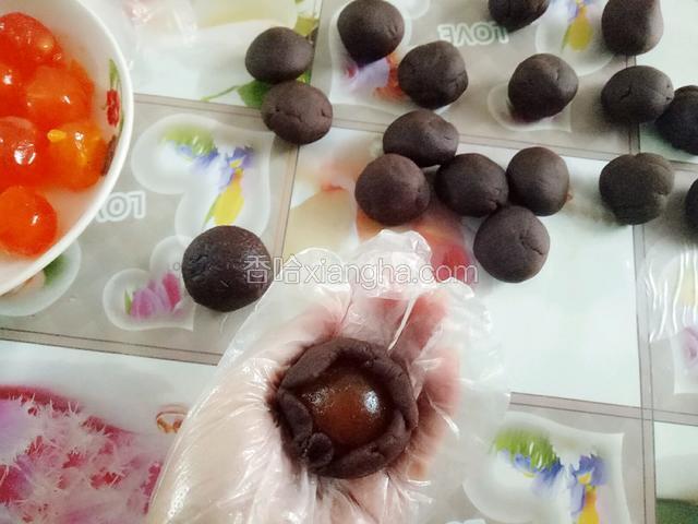 豆沙分成22克一个，每份豆沙包入一个蛋黄，搓圆备用(我是菜场买的蛋黄，冲洗干净晾干后就可以用了，如果是买的真空包装或有腥味的蛋黄，喷高度白酒 170度烤5分钟再包)