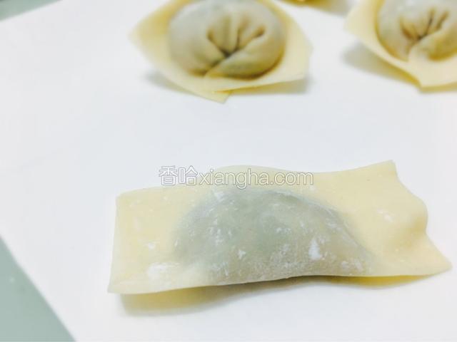 四个边沾取少许清水（不能多），对折馄饨皮，如图