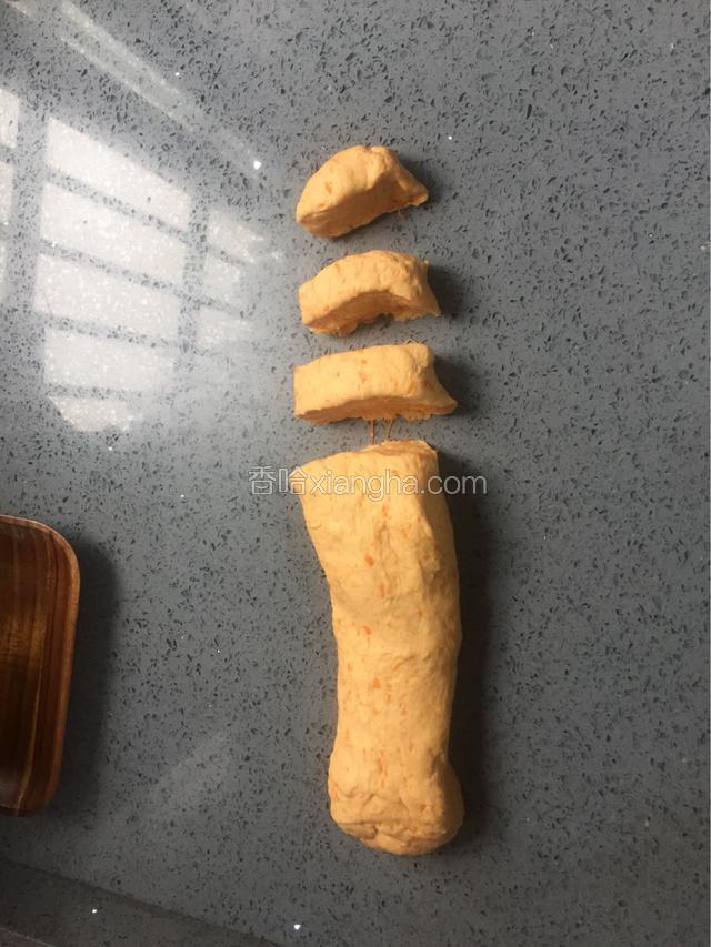 30分钟后揭开保鲜膜，取出面团揉捏均匀，搓成长条，切成10个等量大小的面剂子，约60g一个，