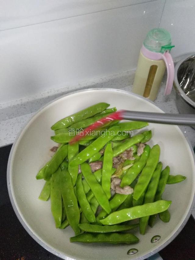 加入豆角，中火翻炒至豆角全部变色。