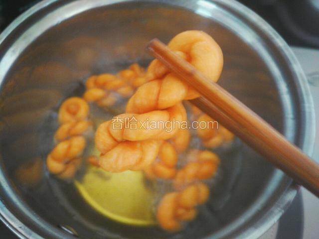 将麻花炸至金黄捞出，放吸油纸上吸掉多余的油
