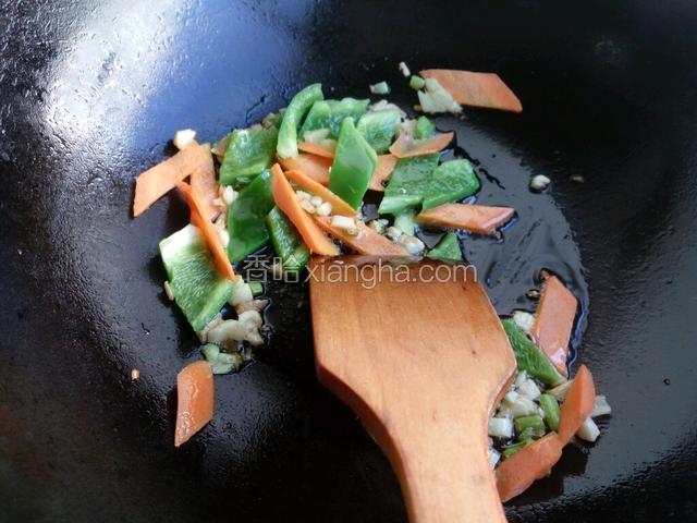 锅中留底油，下入葱姜蒜爆香。下入青椒胡萝卜煸炒。