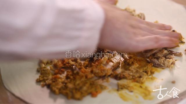 取面团用擀面杖擀开，将蟹粉、蟹黄平铺于上，卷紧，切成段