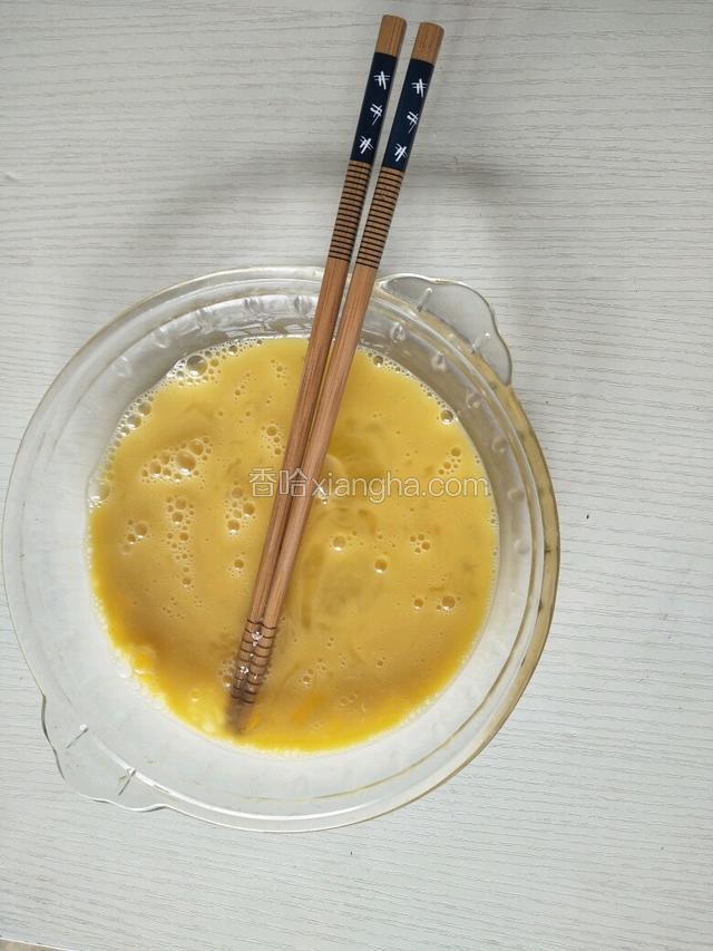 把鸡蛋打入碗里用筷子搅成鸡蛋液。
