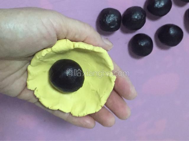 取适量的面，按扁，将豆沙馅包入