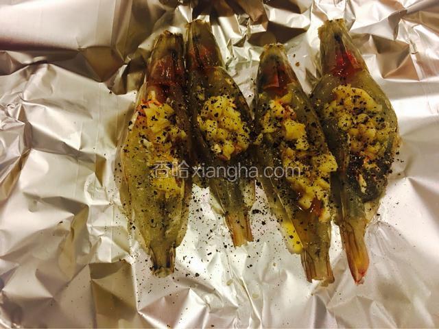 将沙拉酱 大蒜 罗勒 盐 胡椒均匀撒在大虾上面