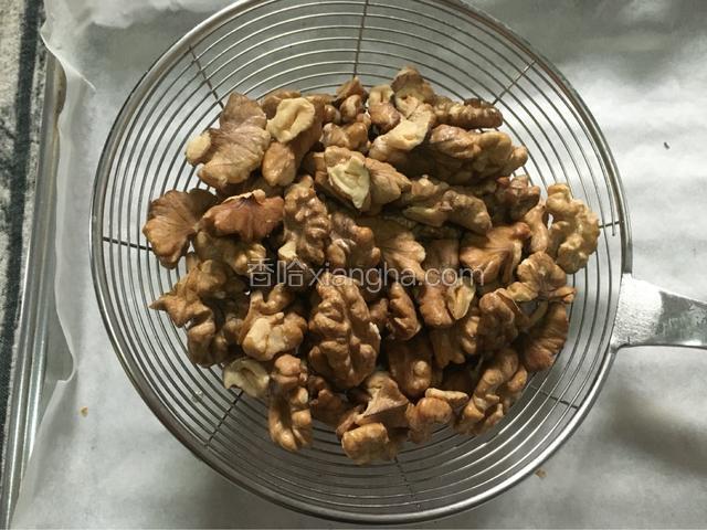 烤箱的时间到了，把核桃仁用网筛筛掉沫沫。