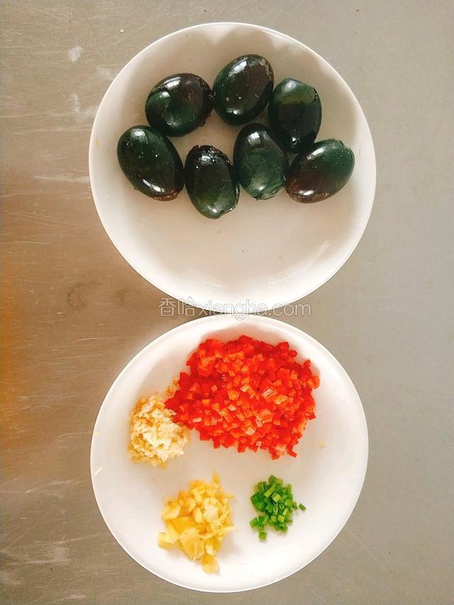 皮蛋去壳装碗，红椒，泰椒剁碎。姜切碎，蒜切沫，葱切丁。