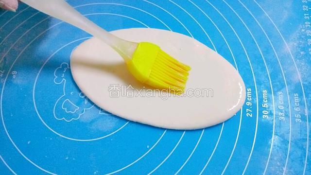 用刷子给面团的一半刷上油，以防粘连。