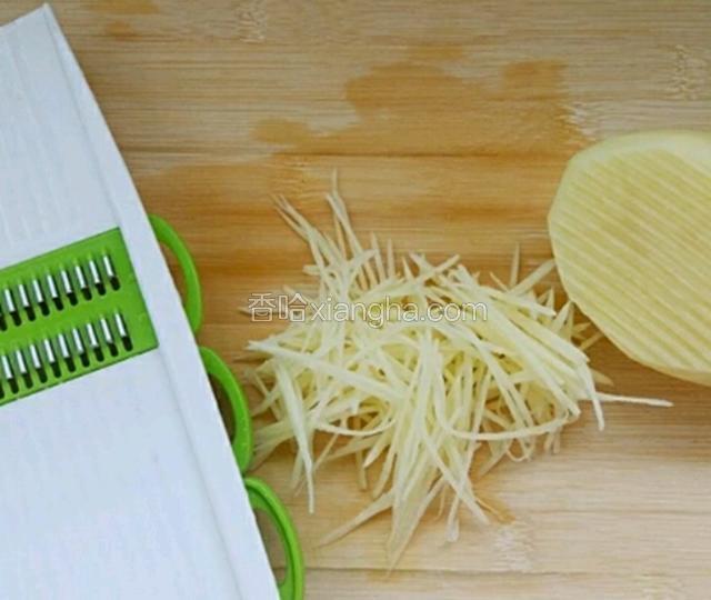 去皮的土豆用擦丝器擦成丝，如果你的刀功足够好也可以用刀切丝。