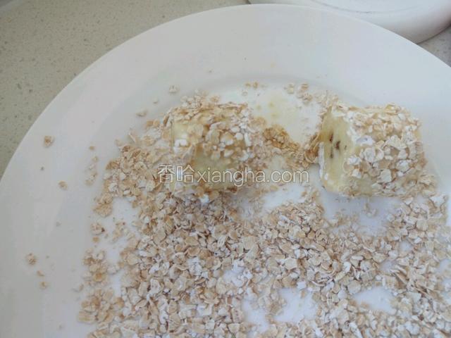 把燕麦片放平盘里，把香蕉条沾满燕麦片滚匀。