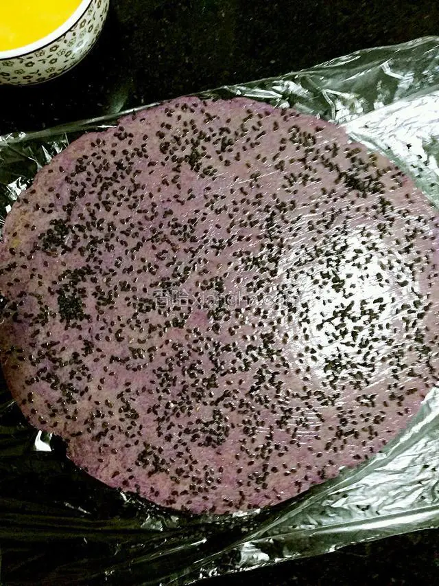 均匀的撒上芝麻并用手轻轻按压下，以防芝麻掉落，黑芝麻白芝麻都可以。