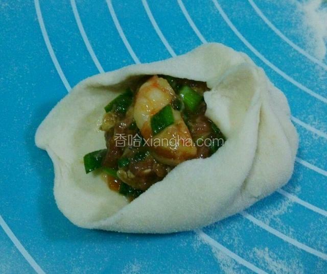 放入馅料，左手拖着面剂，右手拇指食指中指一起逆时针捏褶收口。边捏褶，同时把馅料往里塞下。