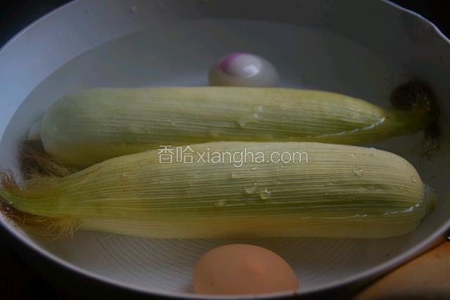 将玉米去掉得只剩下两层外衣，冲洗干净放入锅中