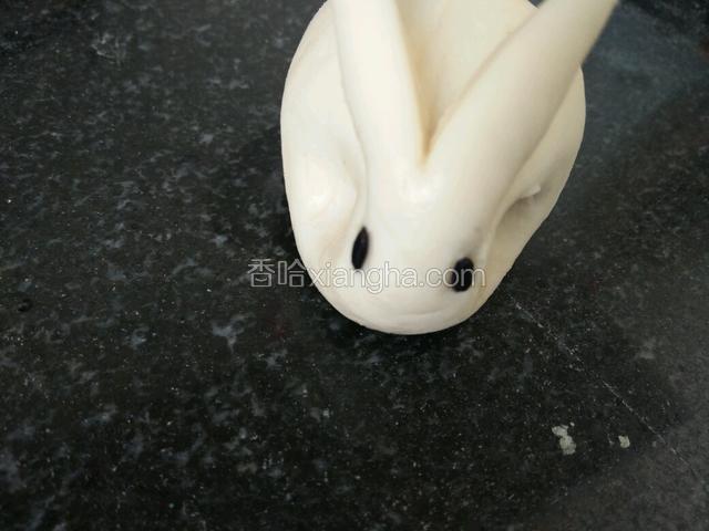 捏出兔子脸，黑米按眼睛，用水黏一下