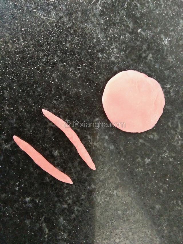 取红色发面团，搓小长条做耳朵装饰，圆饼备用做蝴蝶结