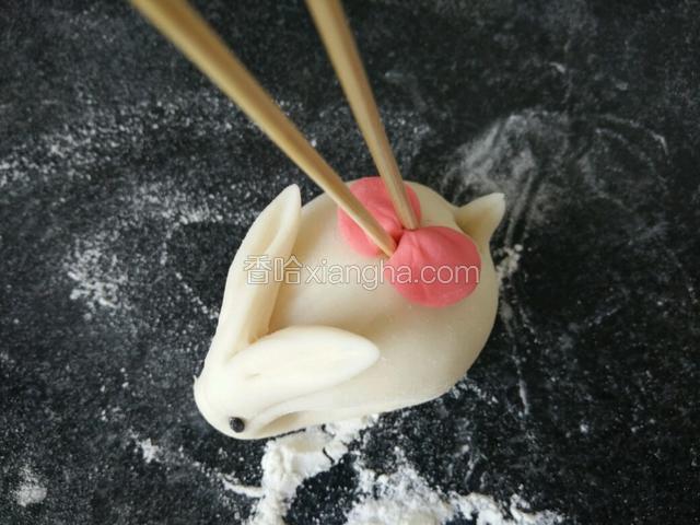 用筷子粘少许水黏在兔背上