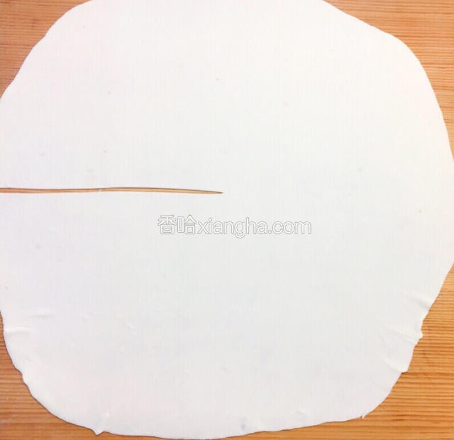 醒好的面分成若干个小面团，取一个面团擀成薄片然后找中心点向外划开。