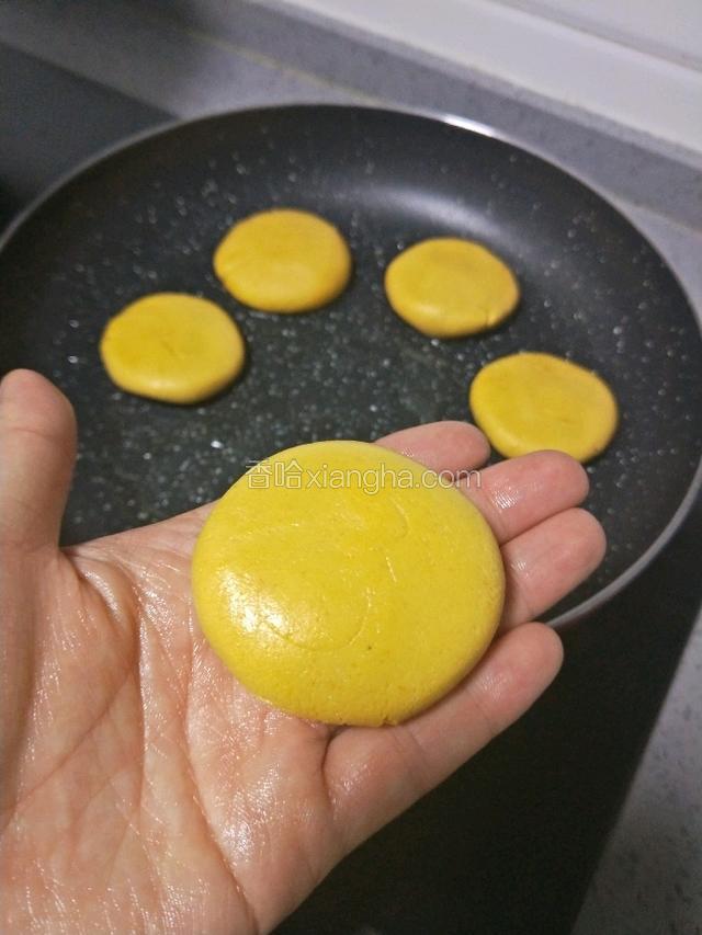 两手挤压剂子成圆饼，锅底刷油，依次碼入