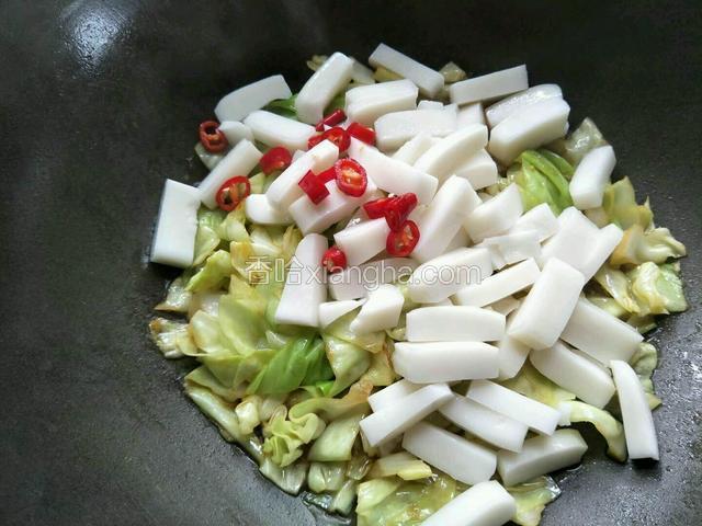 倒入切好的白粿和红尖椒洒适量清水翻炒