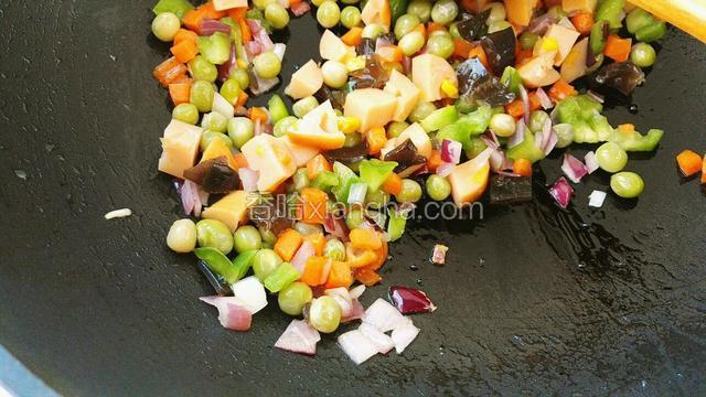 在把剩下的食材一起翻炒。