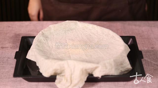 揉成均匀的面团盖上湿布，将面盆坐入温水中，饧面四十分钟；
