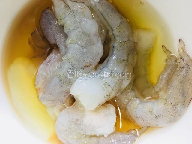 擦干的虾仁用盐、料酒和蛋清抓匀