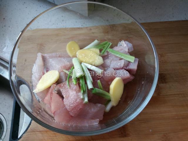 把切好的鱼肉放入碗中，加入葱、姜、盐、鸡精、料酒腌制20分钟。