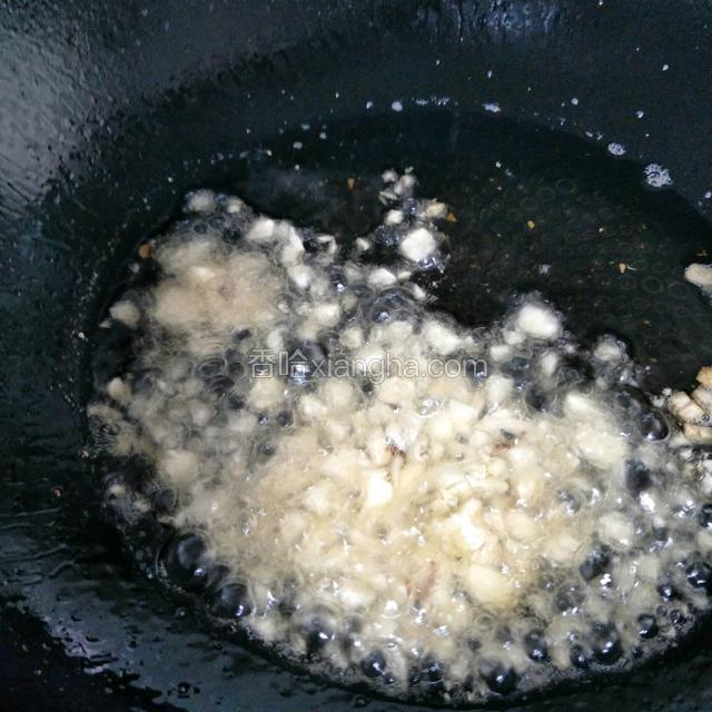 锅里留适当的油放入蒜粒爆香