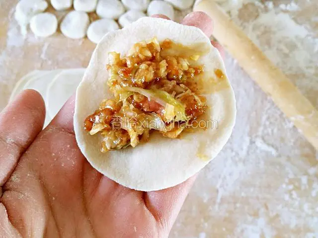 取一张饺子皮，中间放适量馅
