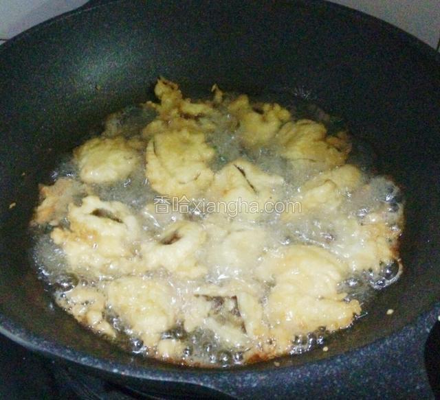 香菇炸定型后翻个，炸至两面金黄色。