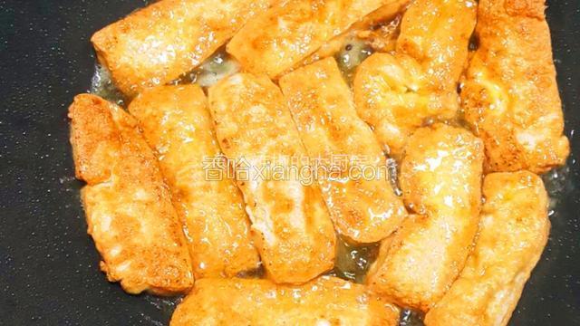  锅底多倒些油，下豆腐，煎至两面金黄，沥油盛出备用