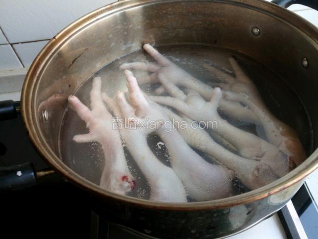 鸡爪剁去趾尖，清洗干净，放沸水中焯一下。