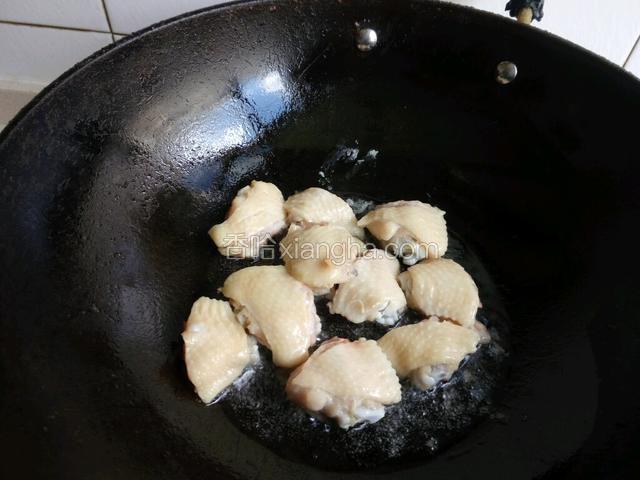 锅中加少许油，煸炒鸡翅。