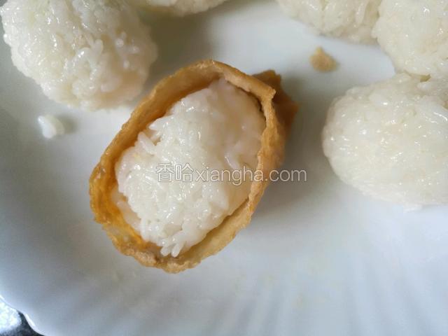 把米饭团成团，放在豆腐口袋里。把豆腐包的边往里面挝一点，这样会非常好看。
