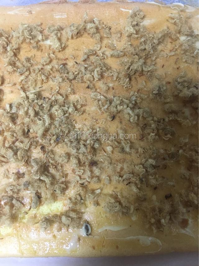 取出蛋糕立马倒扣在案板上，撕掉油纸，再翻面涂上沙拉酱再撒上肉松
