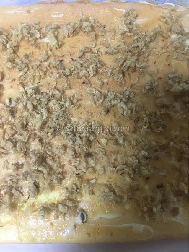 取出蛋糕立马倒扣在案板上，撕掉油纸，再翻面涂上沙拉酱再撒上肉松
