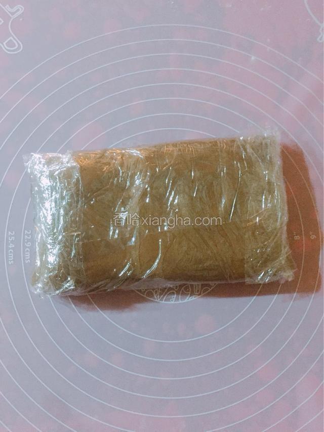 面皮擀平整。翻过来。丑的一面朝上。然后上下折叠。用保鲜膜包裹。放入冰箱冷藏25分钟