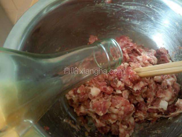肉馅放入盆里 先放点料酒 然后再放入适量清水搅拌 每一次都要等水全部吸收完再加下一次 